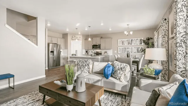 a living room with furniture and a dining table with kitchen view