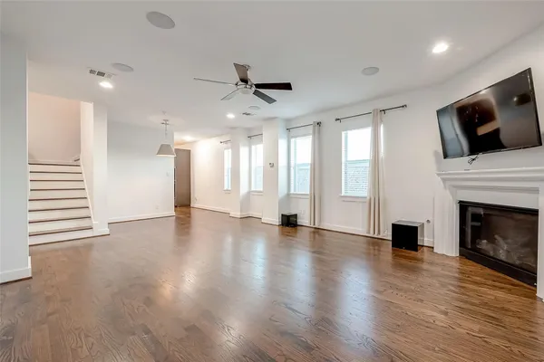 a view of a livingroom with a fireplace wooden floor and staircase