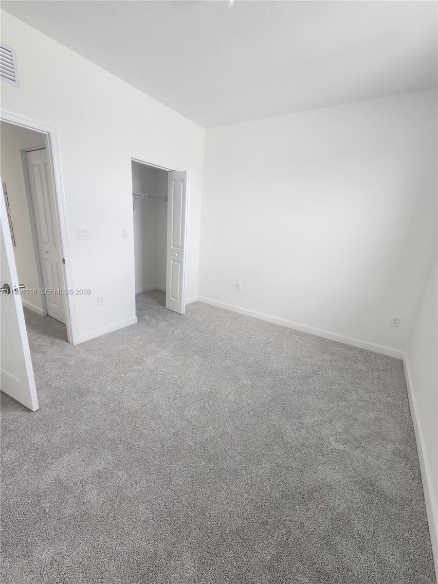 23331 Southwest 128th Avenue, Unit 23331 Homestead, FL 33032 - Photo 12 of 16 an empty room with an entryway