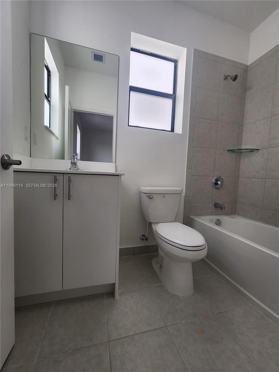 23331 Southwest 128th Avenue, Unit 23331 Homestead, FL 33032 - Photo 14 of 16 a white toilet sitting next to a bathroom sink
