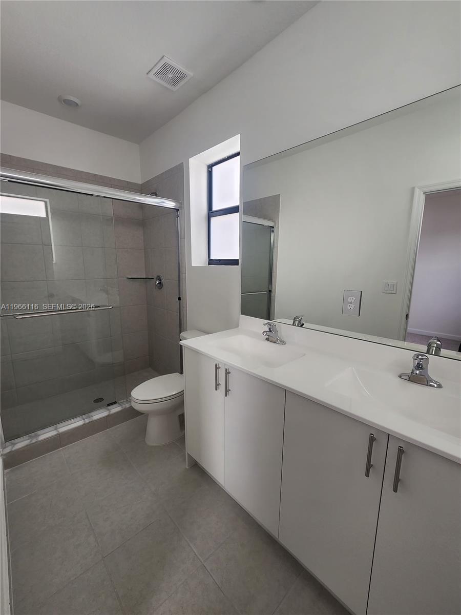 23331 Southwest 128th Avenue, Unit 23331 Homestead, FL 33032 - Photo 15 of 16 a bathroom with a double vanity sink toilet and shower