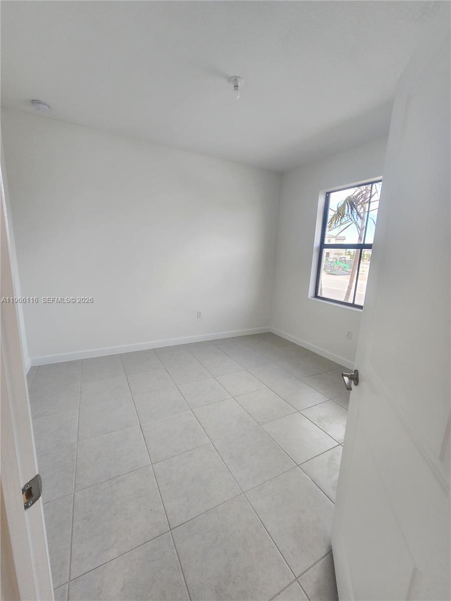 23331 Southwest 128th Avenue, Unit 23331 Homestead, FL 33032 - Photo 10 of 16 an empty room with a window