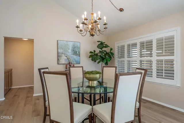 a dining room with furniture potted plants and wooden floor