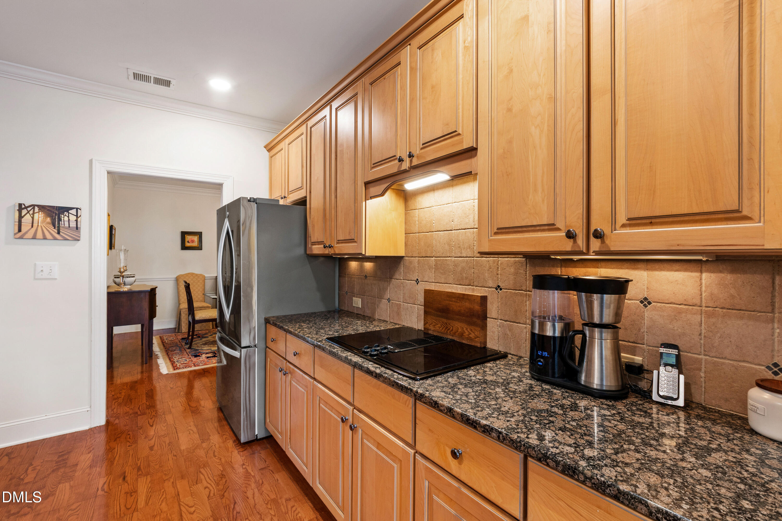 3700 Baron Cooper Pass, Unit 105 Raleigh, NC 27612 - Photo 40 of 49 a kitchen with sink a refrigerator and wooden cabinets