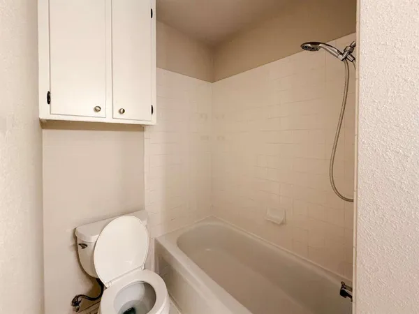 a bathroom with a granite countertop toilet a sink and bathtub
