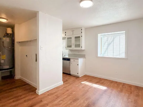 a view of a kitchen with wooden floor and a window