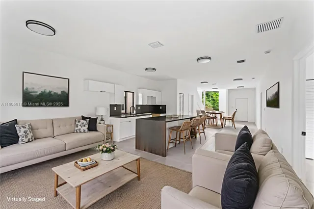 a living room with furniture kitchen view and a window
