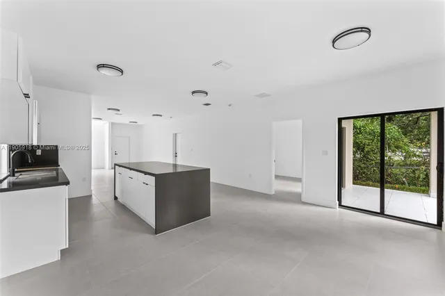 a living room with stainless steel appliances kitchen island furniture and a fireplace