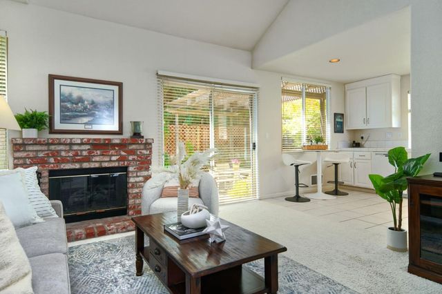 a living room with furniture a fireplace and a potted plant