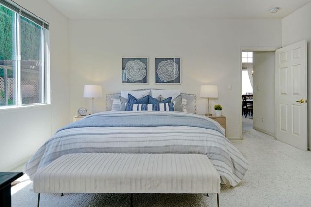 a bedroom with a bed and a painting on the wall