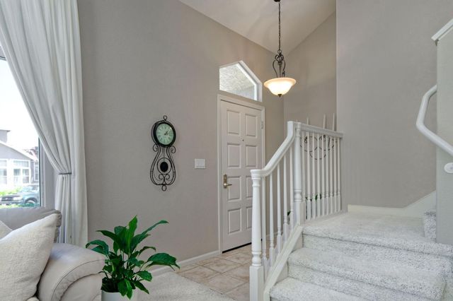 a view of a hallway to a window and potted plants