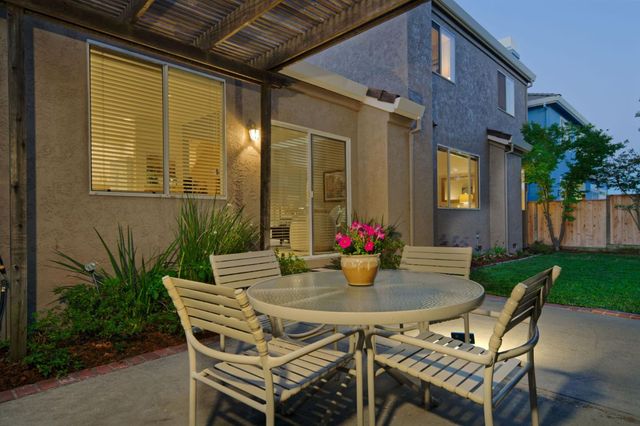a outdoor dining space with a table and chairs