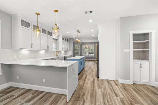 a kitchen with granite countertop a refrigerator stove top oven and sink