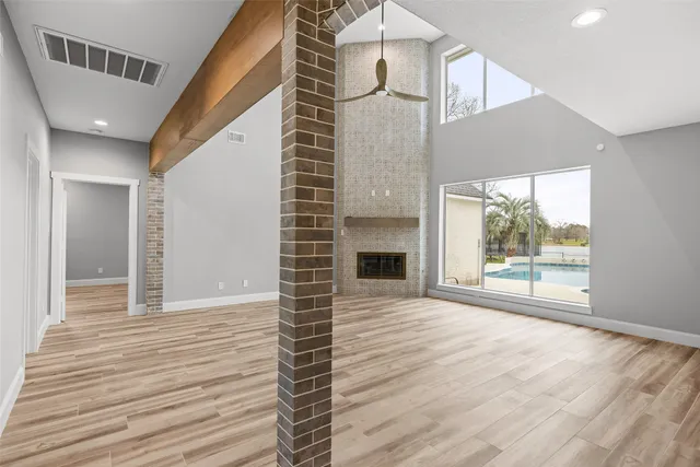 a view of empty room with wooden floor and fireplace
