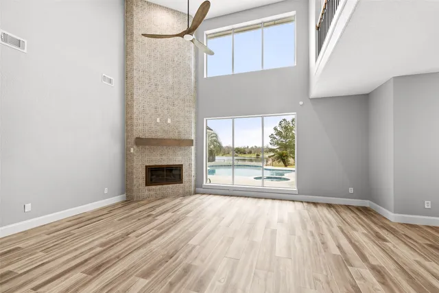 a view of empty room with wooden floor and fireplace