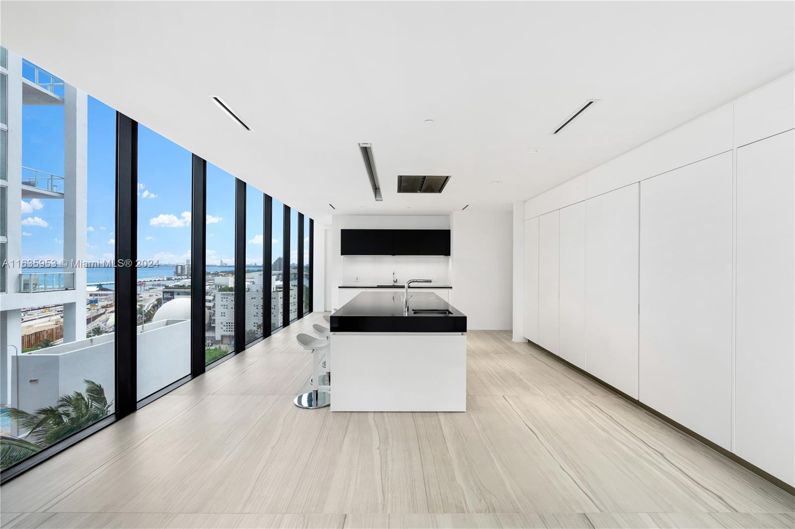 1000 Biscayne Boulevard, Unit 1202 Miami, FL 33132 - Photo 6 of 23 a kitchen with stainless steel appliances a stove top oven and a refrigerator with wooden floor