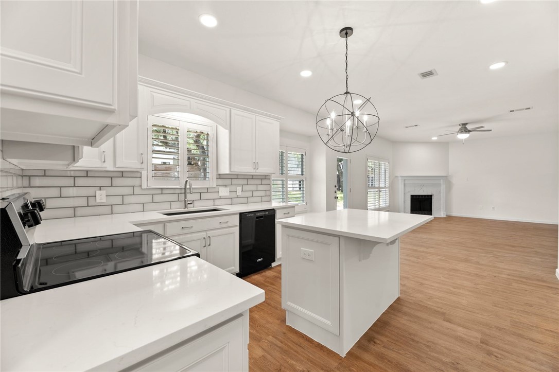a large kitchen with stainless steel appliances a stove oven and a sink with large cabinets