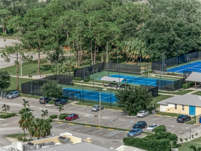 a view of a patio with table and chairs potted plants and large tree