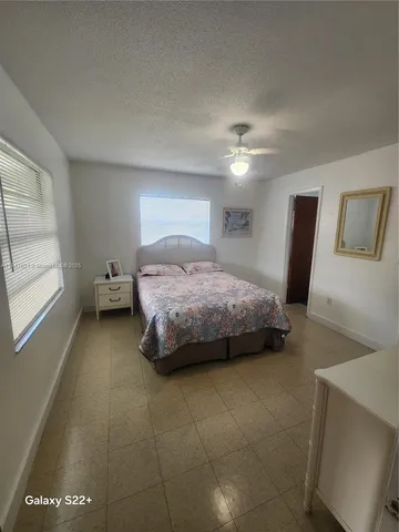 a bedroom with a bed and a ceiling fan