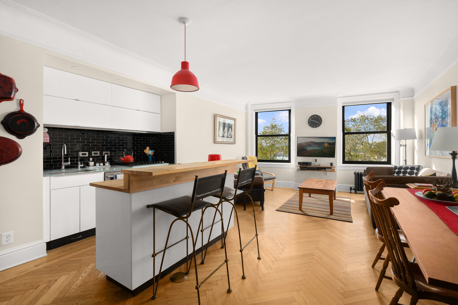 a kitchen with stainless steel appliances granite countertop a stove a sink a dining table and chairs with wooden floor