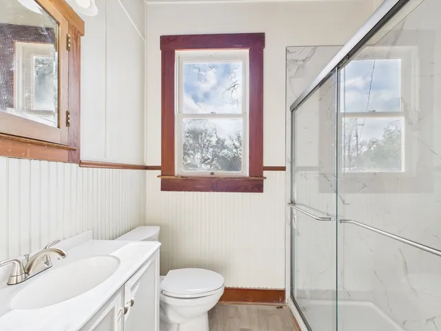 a bathroom with a sink mirror and a toilet