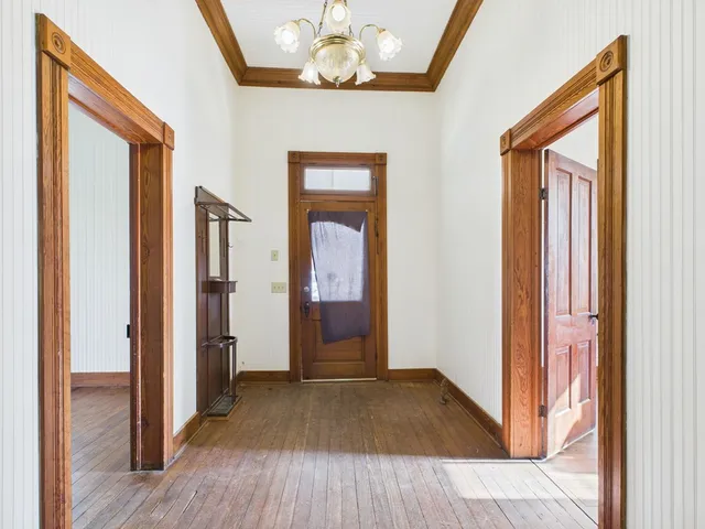 a view of a hallway with wooden floor and staircase