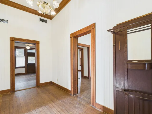 a view of a hallway with wooden floor and a cabinet