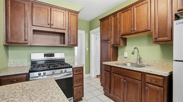 a kitchen with stainless steel appliances granite countertop a sink stove and cabinets