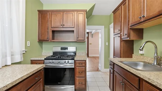 a kitchen with granite countertop a stove sink and refrigerator