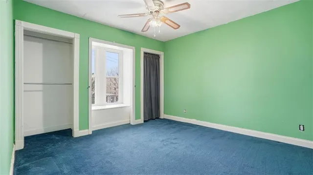 an empty room with chandelier fan