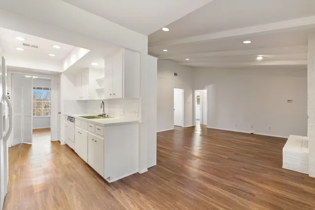 a kitchen with white cabinets and appliances