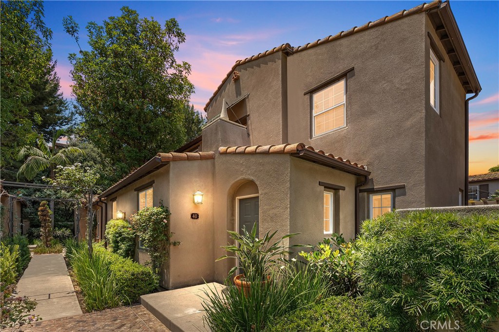 a front view of a house with plants