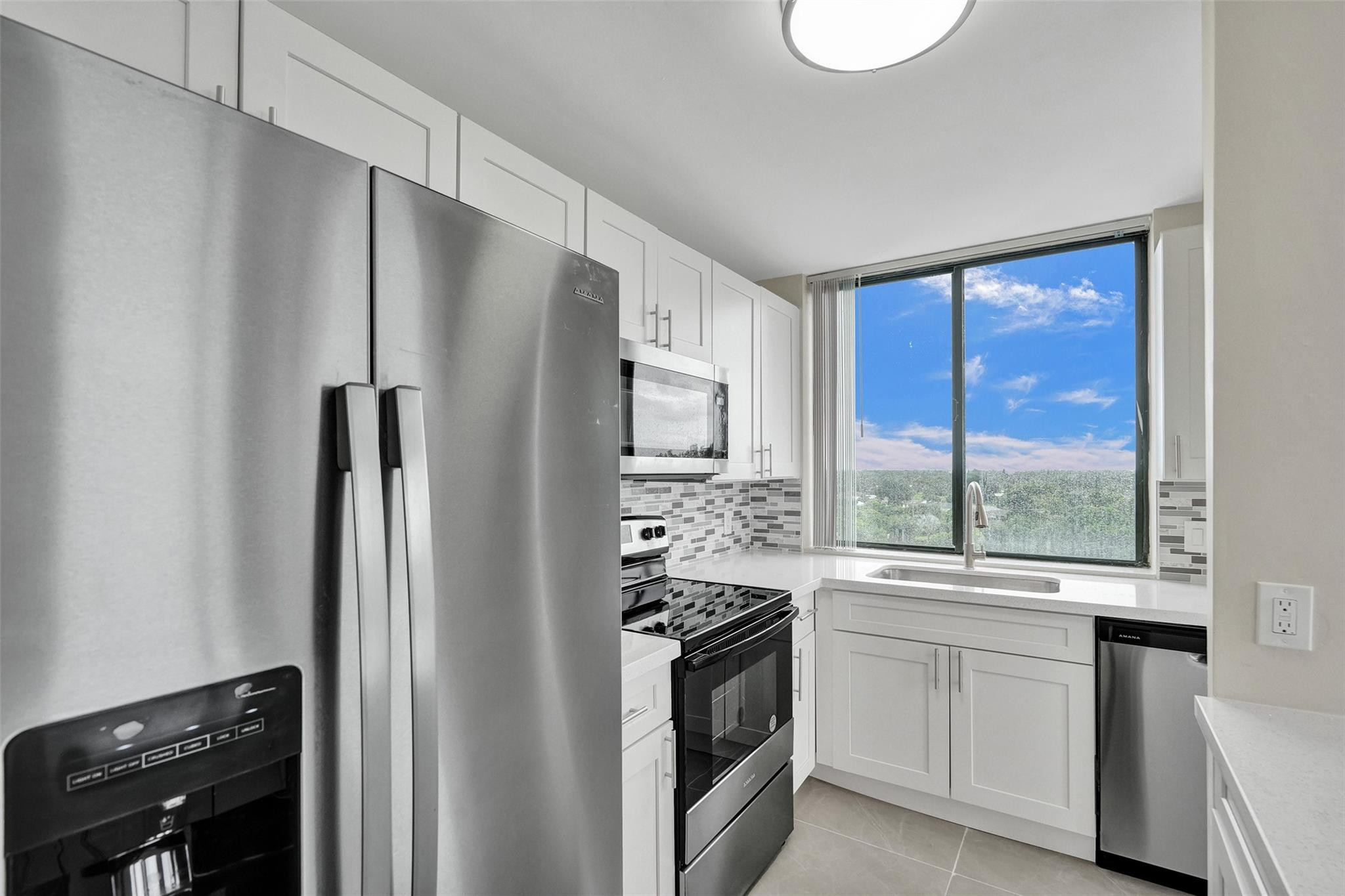 4222 Inverrary Boulevard, Unit 4810 Lauderhill, FL 33319 - Photo 14 of 63 a kitchen with white cabinets and stainless steel appliances