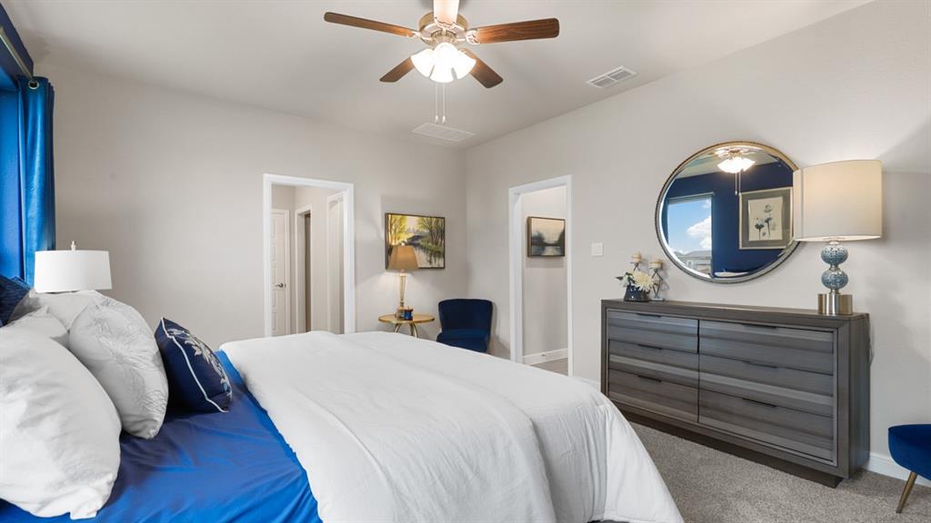 227 Windmill Drive Rhome, TX 76078 - Photo 15 of 34 a bedroom with a bed a mirror and a chandelier