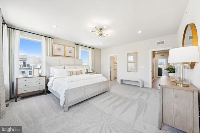 a spacious bedroom with a large bed and a chandelier