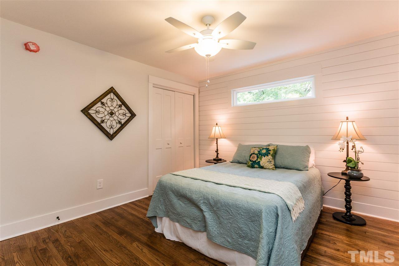 2401 Stevens Road Raleigh, NC 27610 - Photo 8 of 21 a bedroom with a bed and a chandelier