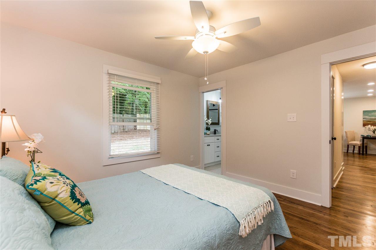 2401 Stevens Road Raleigh, NC 27610 - Photo 9 of 21 a bedroom with a bed and a chandelier