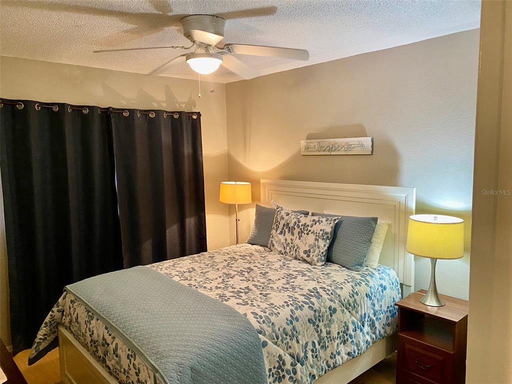 2360 Irish Lane, Unit 64 Clearwater, FL 33763 - Photo 13 of 45 a bedroom with a bed and a lamp on dresser