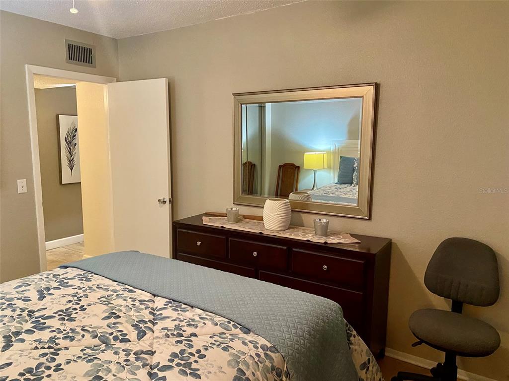 2360 Irish Lane, Unit 64 Clearwater, FL 33763 - Photo 15 of 45 a bedroom with a bed and a mirror