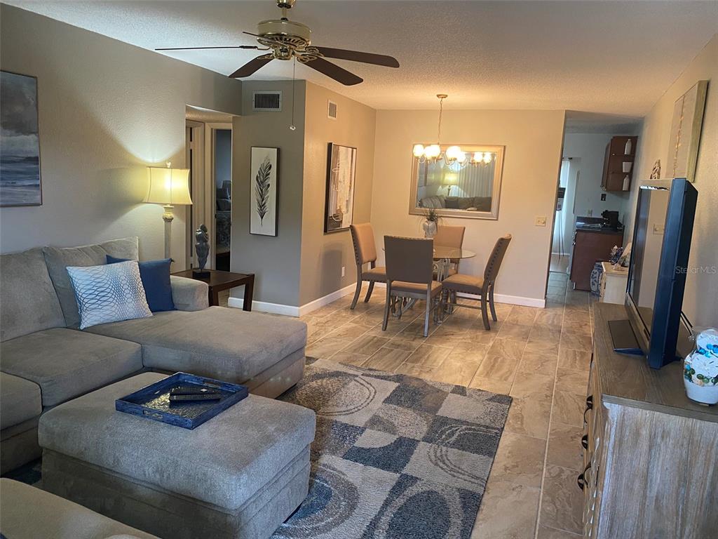 2360 Irish Lane, Unit 64 Clearwater, FL 33763 - Photo 4 of 45 a living room with furniture and a dining table with kitchen appliances