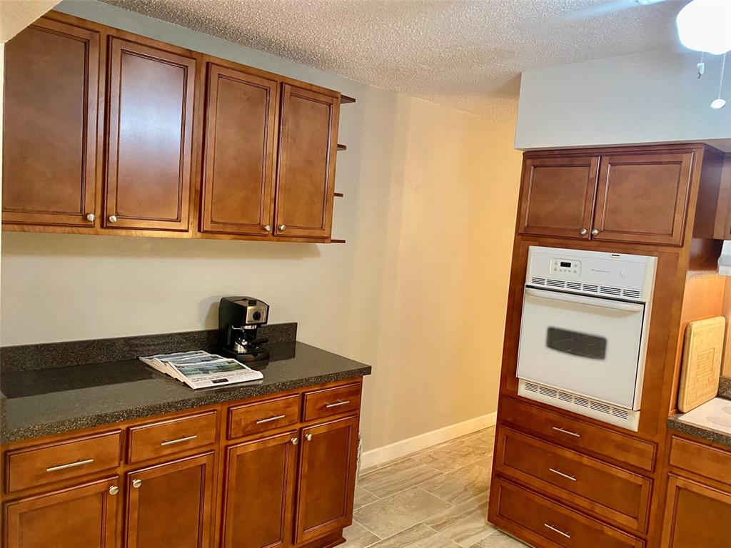 2360 Irish Lane, Unit 64 Clearwater, FL 33763 - Photo 9 of 45 a kitchen with granite countertop cabinets and black appliances