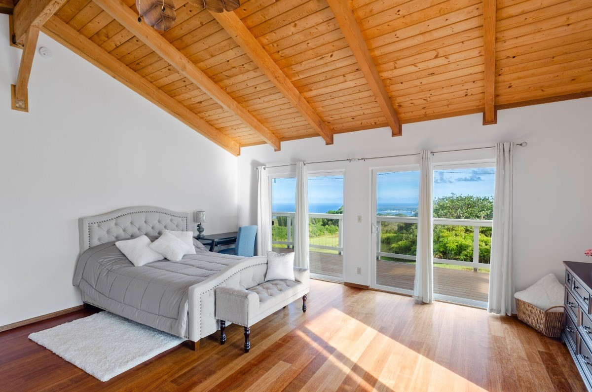 2100 Kaiwiki Road Hilo, HI 96720 - Photo 14 of 29 a spacious bedroom with a bed and wooden floor