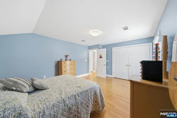 a bedroom with a bed and a refrigerator