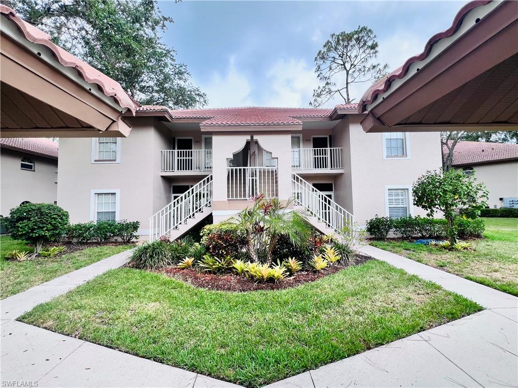 8073 Panther Trail, Unit 1404 Naples, FL 34113 - Photo 1 of 29 a front view of a house with a garden and plants