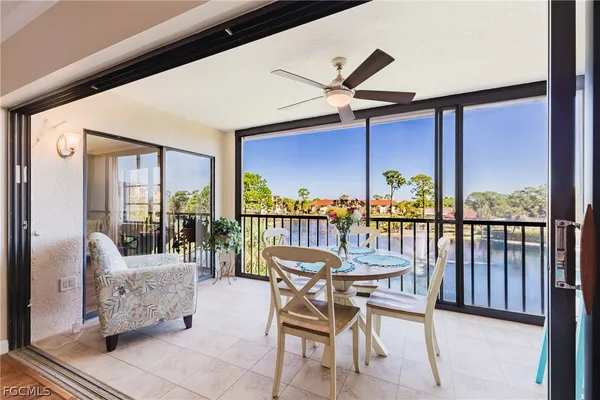 a dining room with furniture and a floor to ceiling window