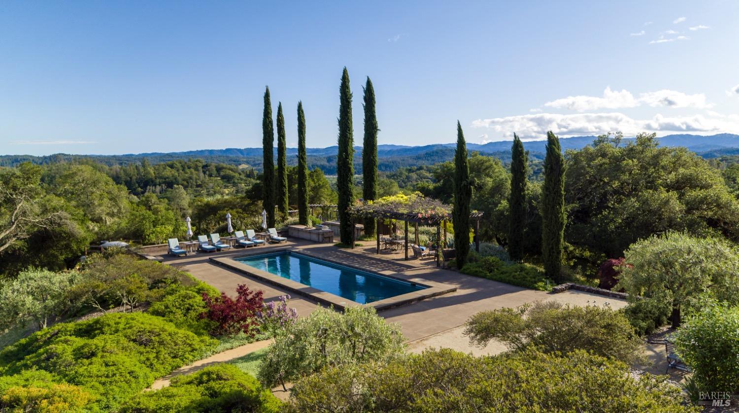 a view of swimming pool with lawn chairs and iron fence