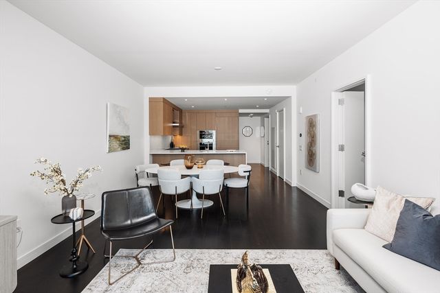 a living room with furniture a wooden floor and a potted plant