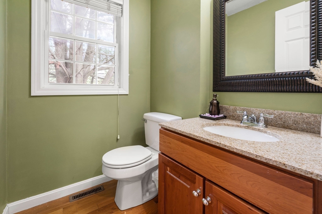 995 Trapelo Road, Unit 1 Waltham, MA 02452 - Photo 9 of 19 a bathroom with a granite countertop toilet sink and mirror