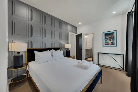 a bedroom with a large bed and a chandelier