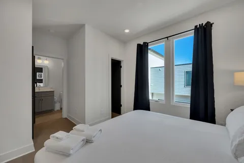 a bedroom with a bed and a view of living room